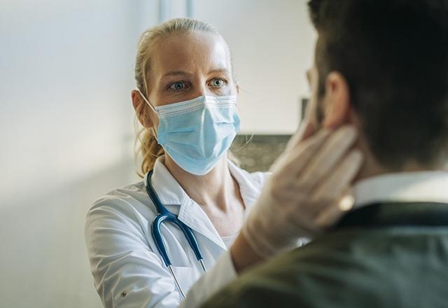 Masked provider checking a patient