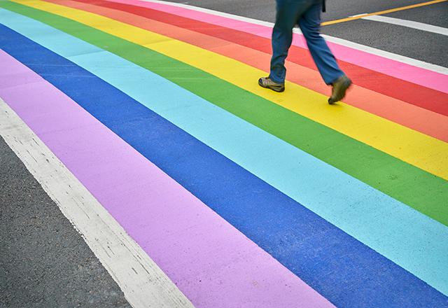 a street's crosswalk painted with a rainbow